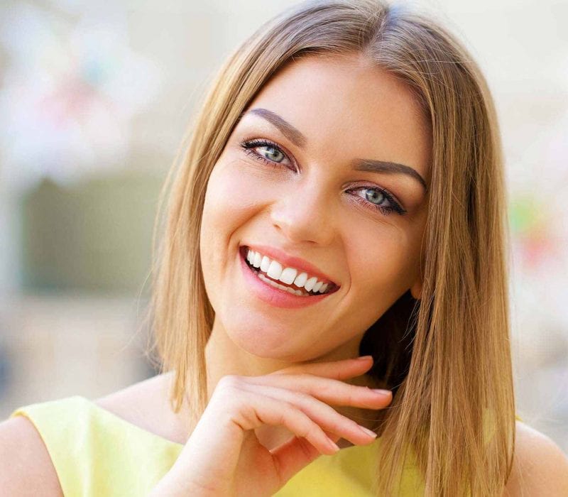 A smiling lady stroking her chin