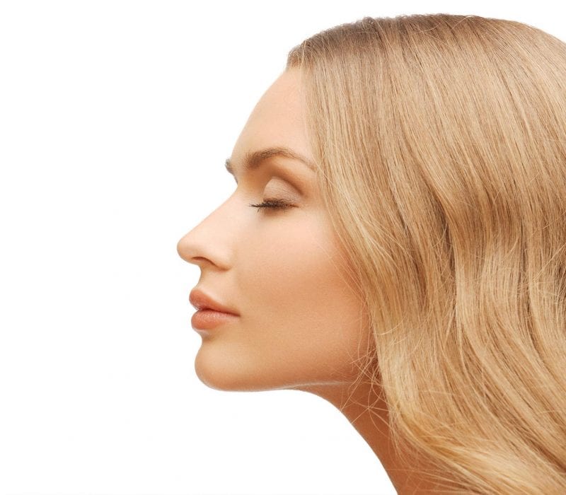 A profile view of a blonde lady with her eyes closed